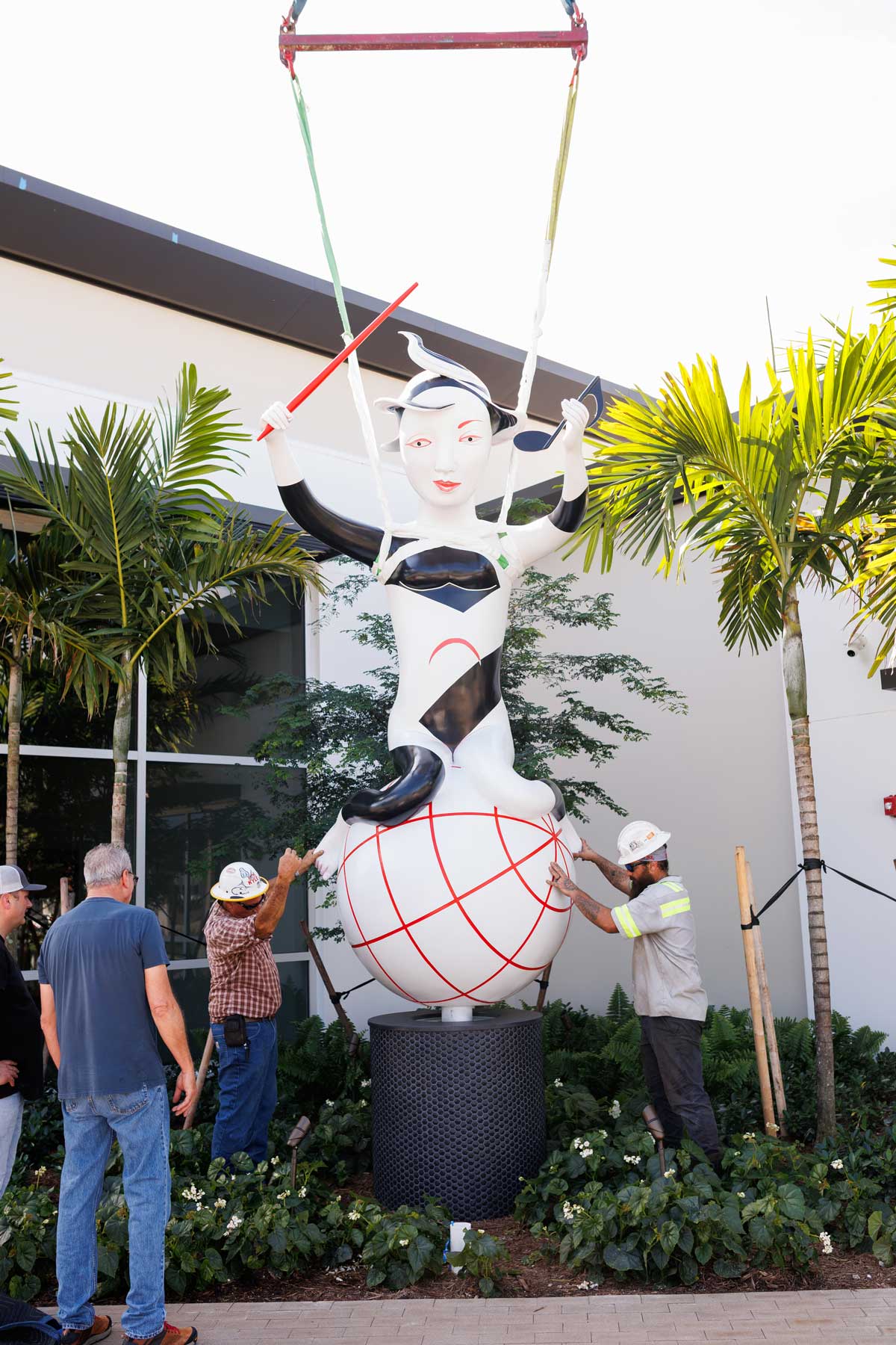 installing cast aluminum and paint sculpture entitled Harmony by artist Patti Warashina, photo by Heather Holt