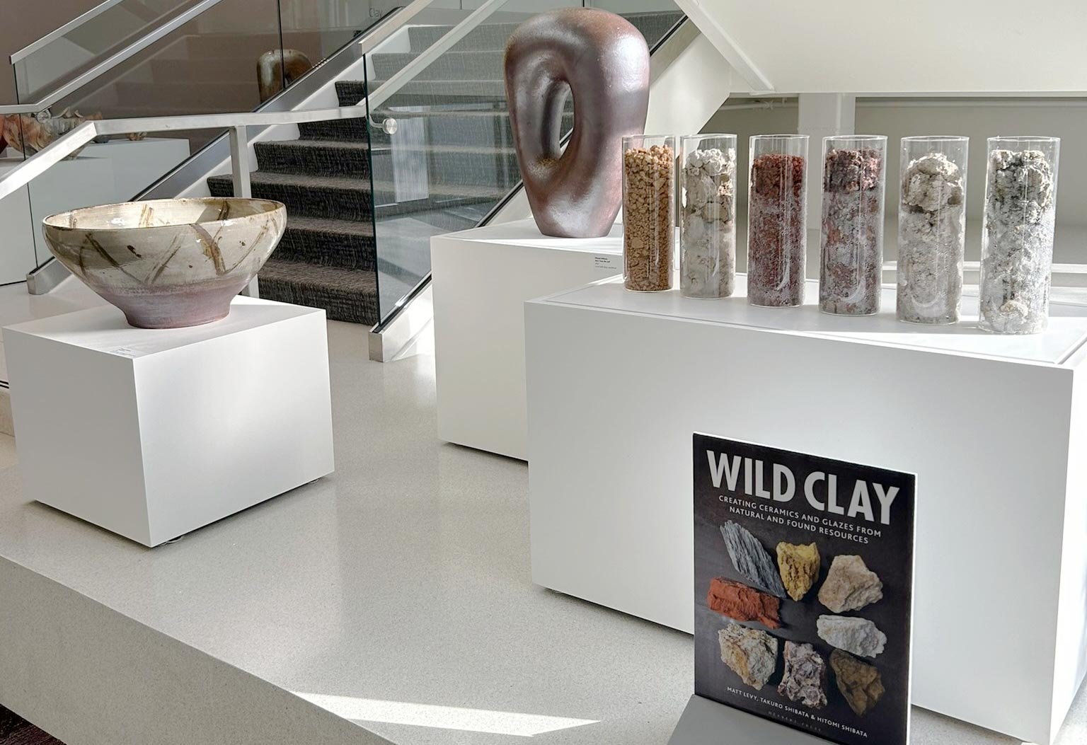 Hitomi and Takuro Shibata, “Ambassadors in Clay,” woodfired stoneware and wild clays, with their book cover, “Wild Clay.”